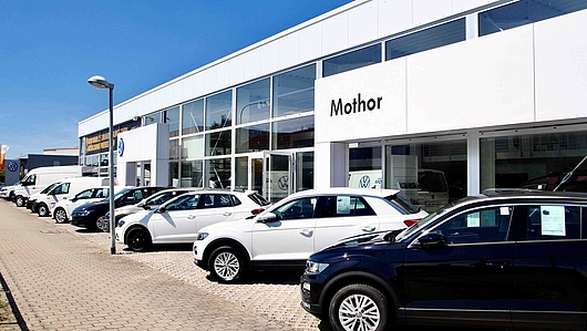 Außenansicht VW Autohaus Mothor in Brandenburg an der Havel mit großem Parkplatz und sehr großem Verkaufsraum sowie Werkstatt.