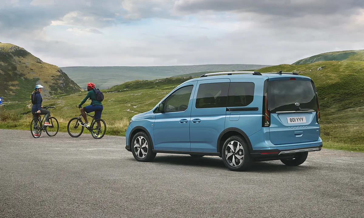 Der Ford Tourneo Connect - stehend im Gebirge mit zwei Fahrradfahrern davor - Jetzt den Tourneo Connect bei deinem Ford Autocenter Mothor in Brandenburg, Stendal oder Gardelegen finanzieren