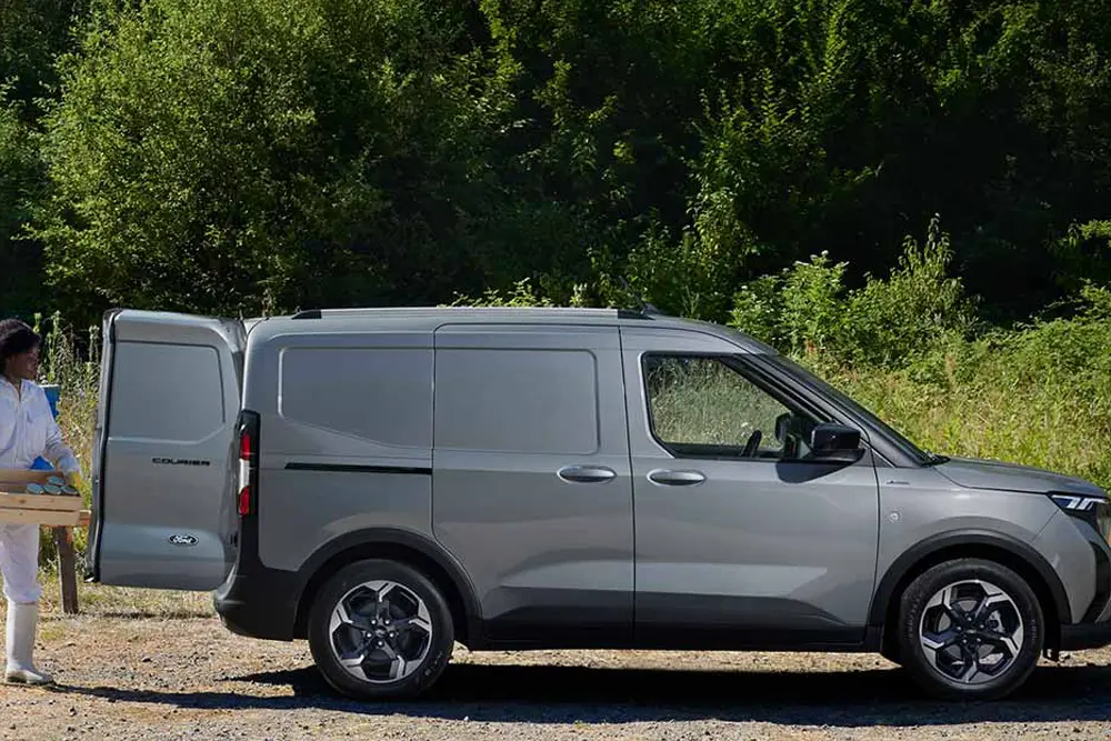 Ford e-Transit Courier Kasten BEV - Frau lädt Baumaterial in das Fahrzeug - Ford im Autocenter Mothor in Stendal, Gardelegen und Brandenburg kaufen, leasen oder finanzieren.