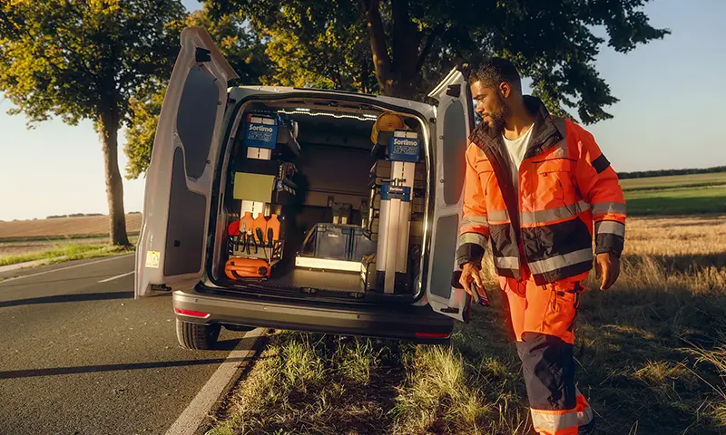 Der Volkswagen Caddy Cargo - Hanwerker außerhalb des Caddy, nimmt Werkzeug aus dem Caddy - Jetzt deinen Volkswagen bei deinem Volkswagen Autohaus Mothor in Brandenburg leasen oder finanzieren oder kaufen