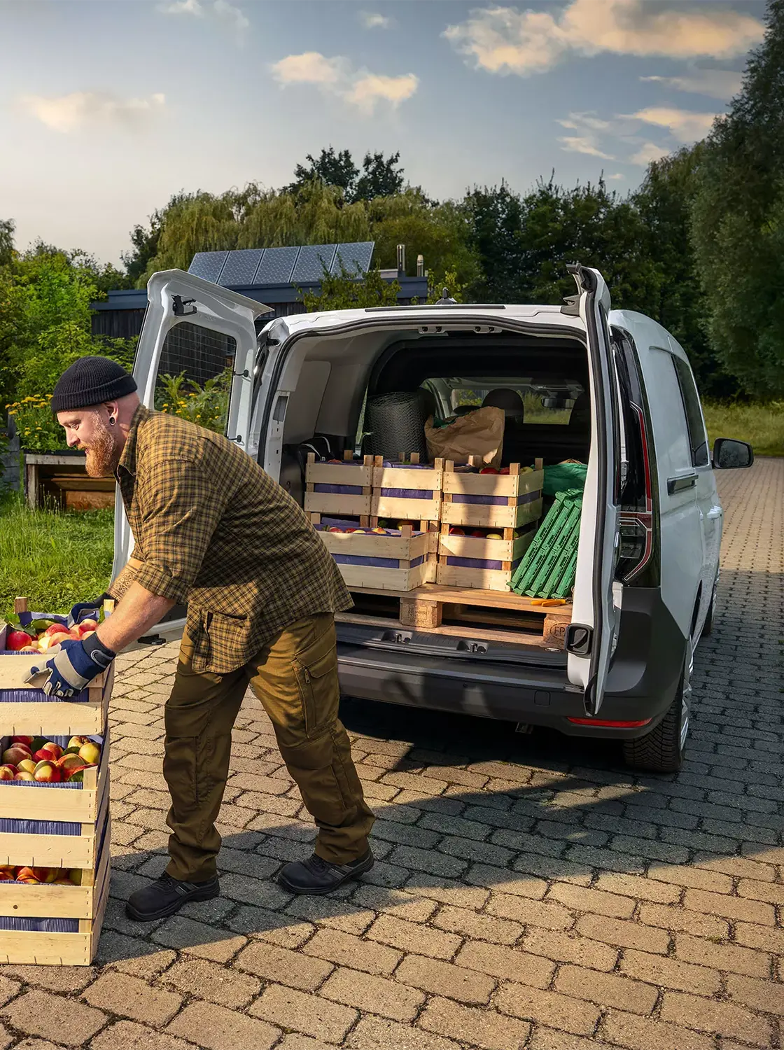 Der Volkswagen Caddy Cargo - Heckansicht, Obstbauer beim Entladen der Ware - Jetzt deinen Volkswagen bei deinem Volkswagen Autohaus Mothor in Brandenburg leasen oder finanzieren oder kaufen